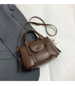 Dettaglio borsa retrò marrone scuro con trama in pelle increspata e ciondolo di peluche