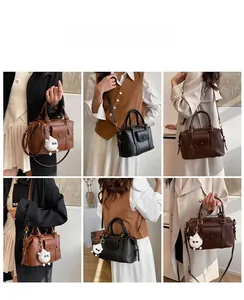 Dettagli della borsa vintage in pelle marrone e nera con ciondolo a pecora e tracolla
