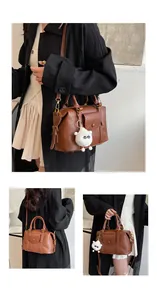 Dettaglio di una borsa Boston vintage marrone con ciondolo a pecora e tracolla