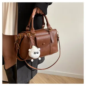 Dettaglio della borsa Boston vintage in pelle PU marrone con ciondolo a agnellino