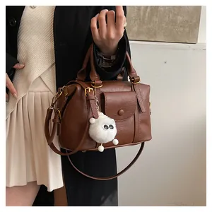 Borsa Boston retrò marrone con un ciondolo di peluche bianco e texture in pelle fine