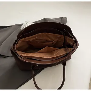 Detailed interior view of the dark brown tote bag with zipper pockets and spacious lining