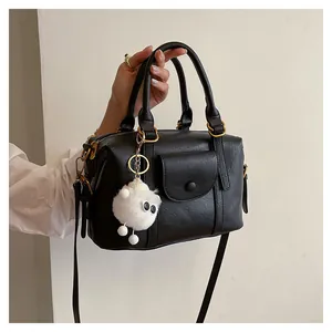 Dettaglio di una borsa retrò nera con ciondolo a pecorella e finiture in oro antico