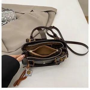 Top view of brown faux leather bag showing spacious triple-compartment interior
