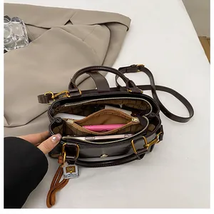 Deep brown shoulder bag showing spacious interior compartments and patterned lining