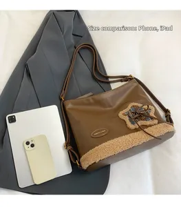Detaillierter Größenvergleich der braunen Softledertasche mit einem iPad und Handy