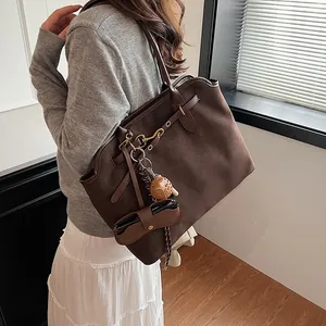 Frosted suede large tote bag in dark brown with gold hardware shown on a female model