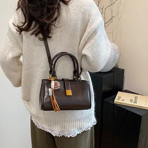Deep coffee brown rectangle handbag with gold hardware and stylish tassel charm