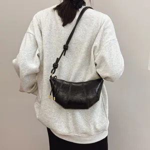 Minimalist black crescent croissant bag with knot detail shoulder strap on model