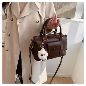 Dettaglio borsa Boston vintage marrone scuro con ciondolo a pecora e manici