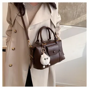 Dettaglio della borsa vintage in pelle marrone scuro con ciondolo a pecora e tracolla
