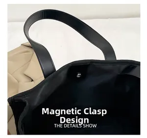 Detail of a black canvas tote bag featuring a secure metal magnetic closure design