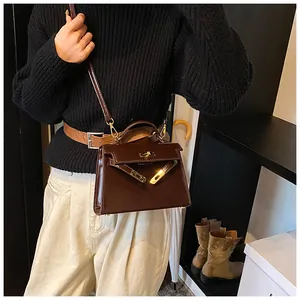 Sac Kelly en cuir vernis marron foncé gros plan sur les détails métalliques et élégants.