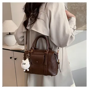 Dettaglio borsa Boston marrone scuro con tasca frontale e ciondolo a forma di pecora