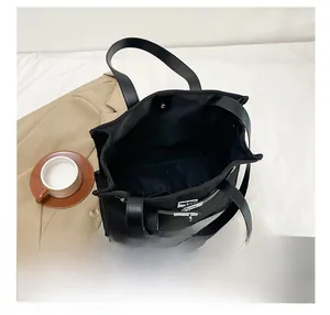 Detail view of the spacious interior of a black canvas tote bag with Kelly lock hardware