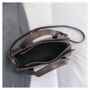 Deep brown tote interior view showing black fabric lining and functional zip pocket