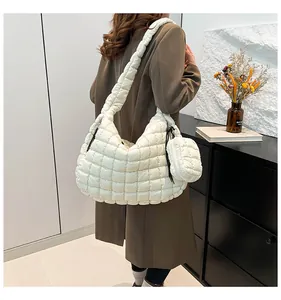 Detail of white quilted puffer tote with matching round coin purse and padded shoulder strap