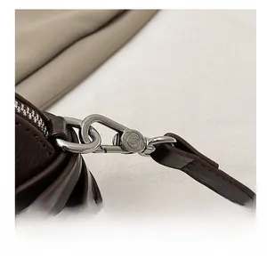 Detail of silver metal hook and zipper on dark brown leather shoulder bag strap