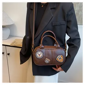 Brown vintage faux leather crossbody bag with retro patches shown in a styled setting