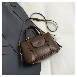 Dettaglio della pelle marrone scuro e della tracolla regolabile della borsa vintage
