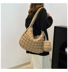 Detail of khaki quilted puffer hobo bag with matching mini pouch and padded strap