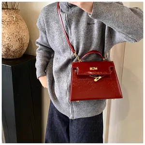 Sac à main femme en cuir verni rouge classique style Kelly bandoulière avec serrure.