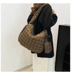 Macro detail of large brown quilted cloud bag with matching strap and mini pouch accessory
