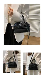 Detailed view of the black patent leather shell bag with silver buckles and sleek finish