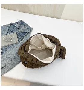 Internal view of brown quilted dumpling bag with off-white lining and interior pocket