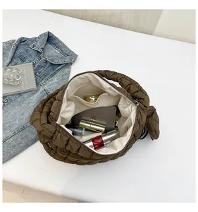 Detail view of the dark brown quilted bag interior with a functional inner pocket