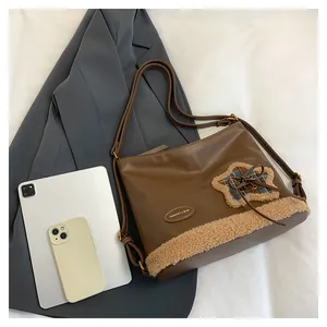 Detail der braunen Ledertasche mit Stern-Patch, Schleife und großem Innenvolumen