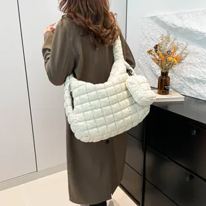 Quilted white cloud shoulder bag with mini pouch shown on model in a modern room