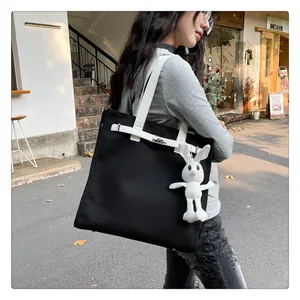 Detail of canvas tote bag with black and white contrast and silver metal lock closure