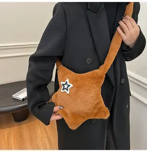 Borsa a tracolla a stella in peluche marrone indossata con un cappotto nero di classe
