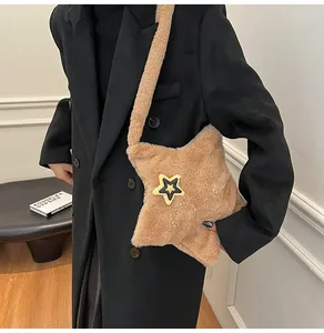 Dettaglio della borsa a stella in peluche cammello con consistenza morbida su cappotto nero