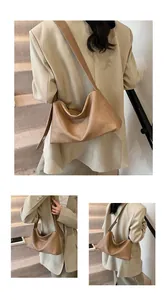Détail de la texture en cuir souple caramel et de la fermeture éclair du sac Boston