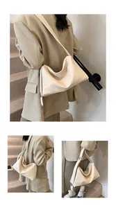 Détail du sac en cuir beige souple avec bandoulière large minimaliste et finitions argentées chic