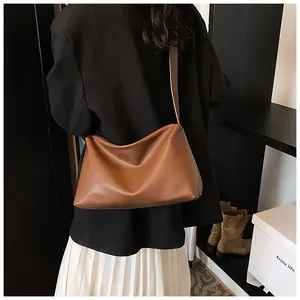 Vue arrière d'un mannequin portant un sac à bandoulière en cuir marron vintage élégant