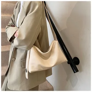 Détail du sac hobo en cuir beige avec bandoulière large et boucle en métal argenté