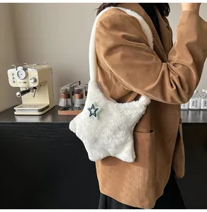 Dettaglio di una borsa a tracolla in peluche bianca a forma di stella su una modella