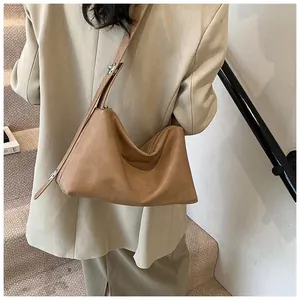Vue détaillée de la sangle réglable et de la texture mate du sac Boston marron chaud