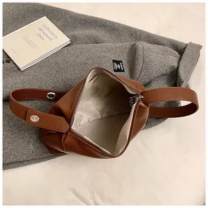 Détail du sac Boston en cuir marron montrant la doublure beige et la poche zippée