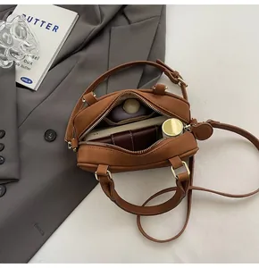 Top-down view of a brown box bag interior showing capacity for phone and cosmetics