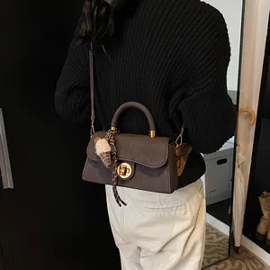 Bruine matleren crossbodytas met gouden gesp en pluche hanger voor dames