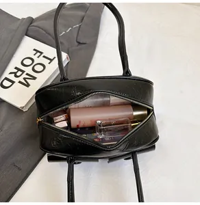 Top-down view of black faux leather shoulder bag interior showing large storage capacity