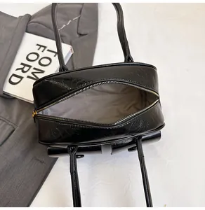 Top view of large black glossy crinkled leather tote with metal zipper and grey lining