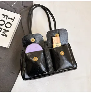 Close-up of black retro shoulder bag showing multiple functional pockets and inner storage