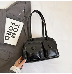 Close-up of glossy retro shoulder bag with double flap pockets and metallic buttons