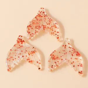 Vue détaillée de trois pendentifs queue de sirène en résine transparente avec paillettes