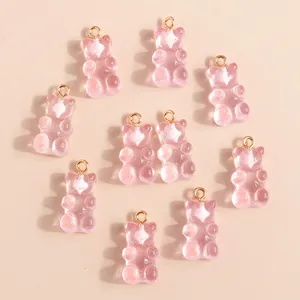 Detail of translucent pink resin bear pendants with gold metal rings for DIY jewelry
